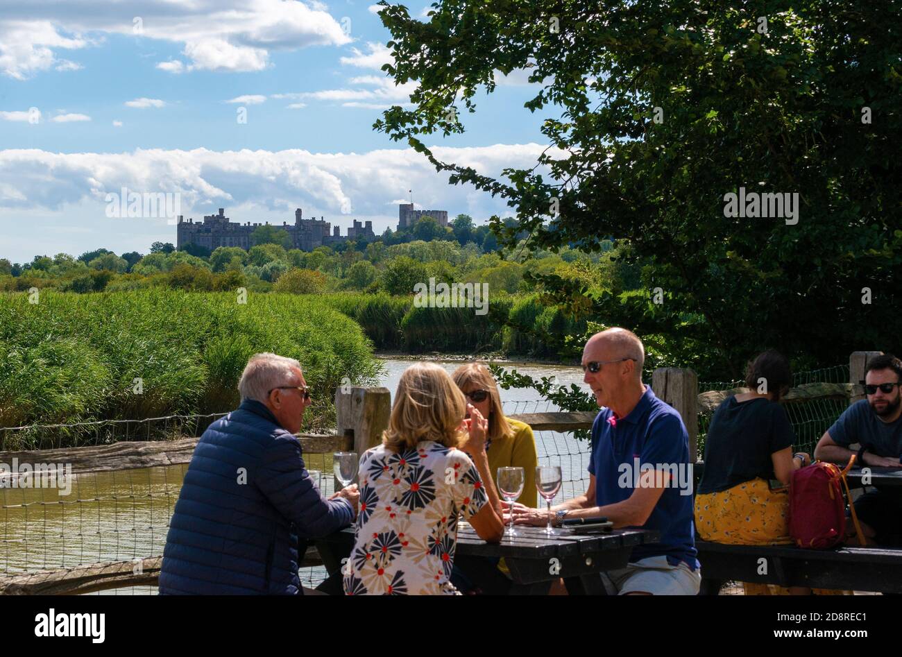 Customers at the Black Rabbit public house in summer sitting having a drink beside the tidal River Arun, Arundel, West Sussex, England, UK Stock Photo