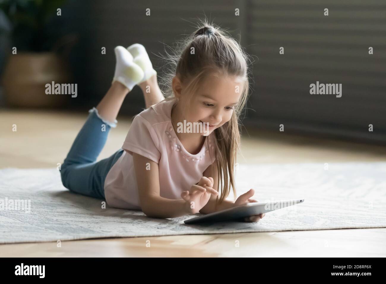 Happy little preschool child girl using computer tablet. Stock Photo