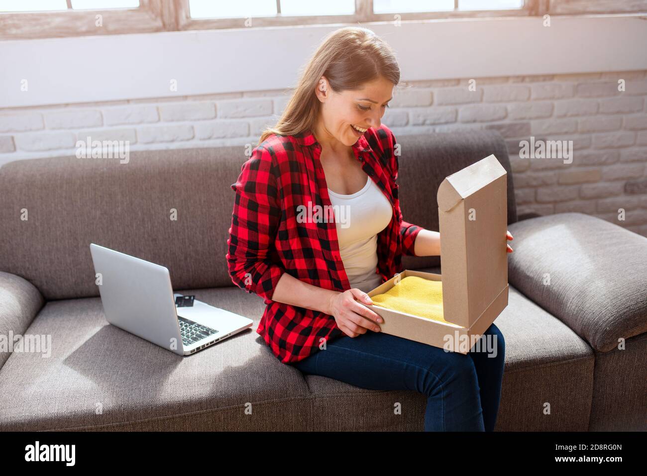 Happy woman has received a package of an online ordered Stock Photo