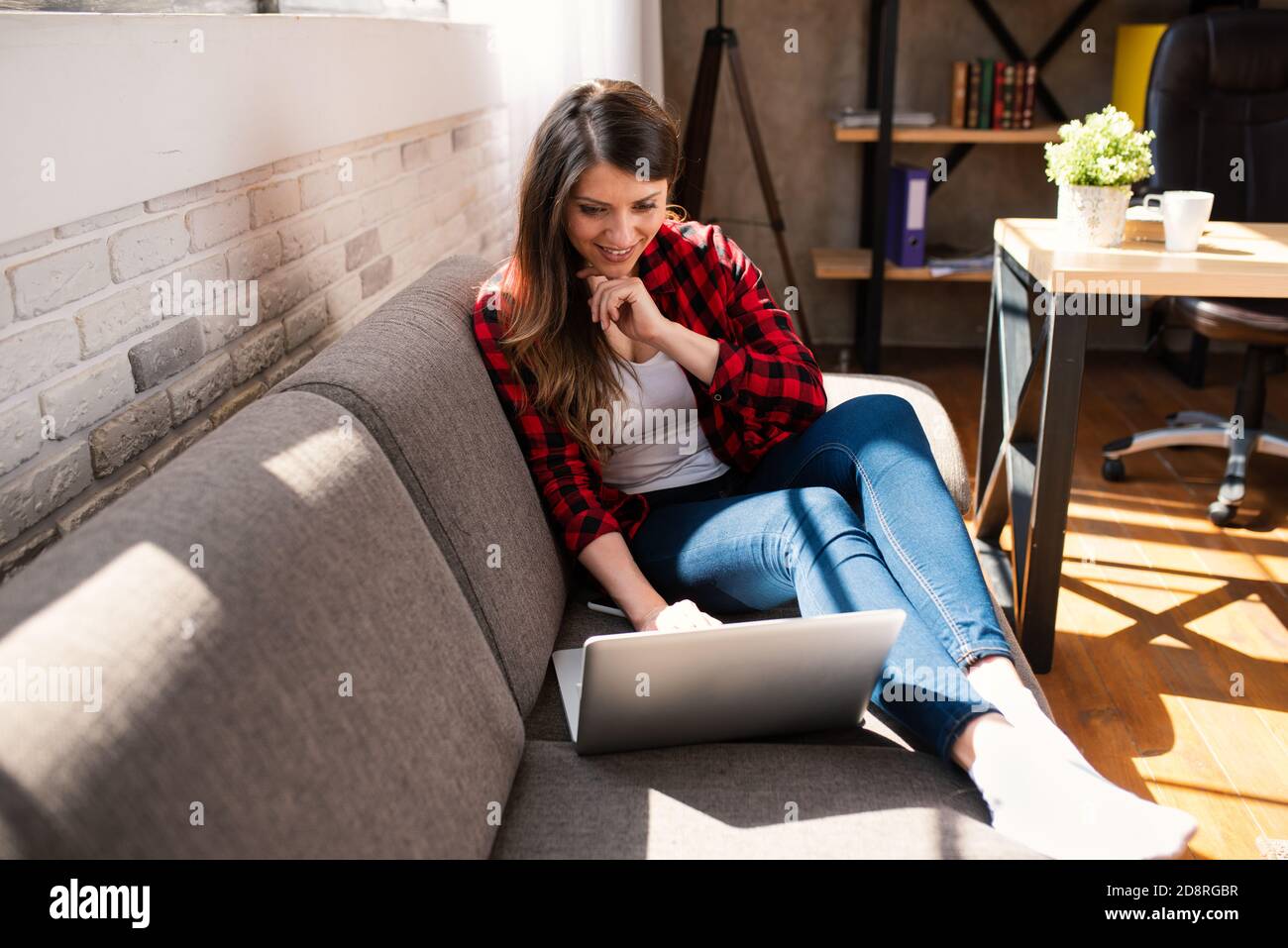 Woman teleworker works at home with a laptop. She is in smart working due to covid-19 pandemic Stock Photo