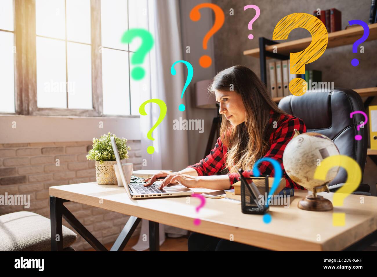 Woman teleworker works at home with a laptop with a lot of questions. She is in smart working due to covid-19 pandemic Stock Photo