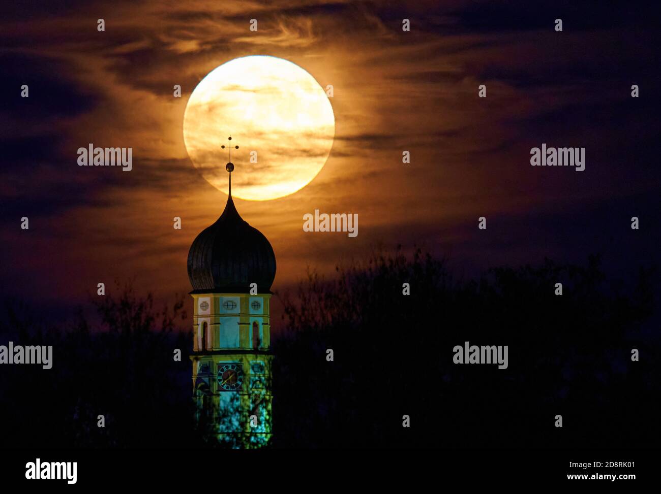 Full Moon, the rising, appearance of the moon over the horizon behind the baroque church of St. Martin, the Catholic parish church of Marktoberdorf i Stock Photo