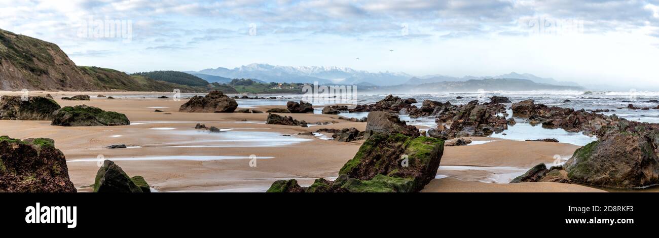 A panorama view of wild and rocky and sandy beach at low tide Stock Photo