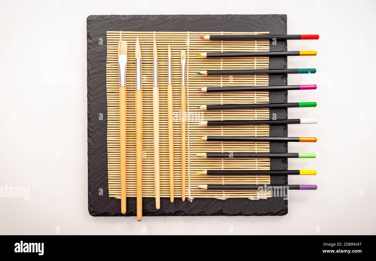 Coloured pencils on a straw mat Stock Photo Alamy
