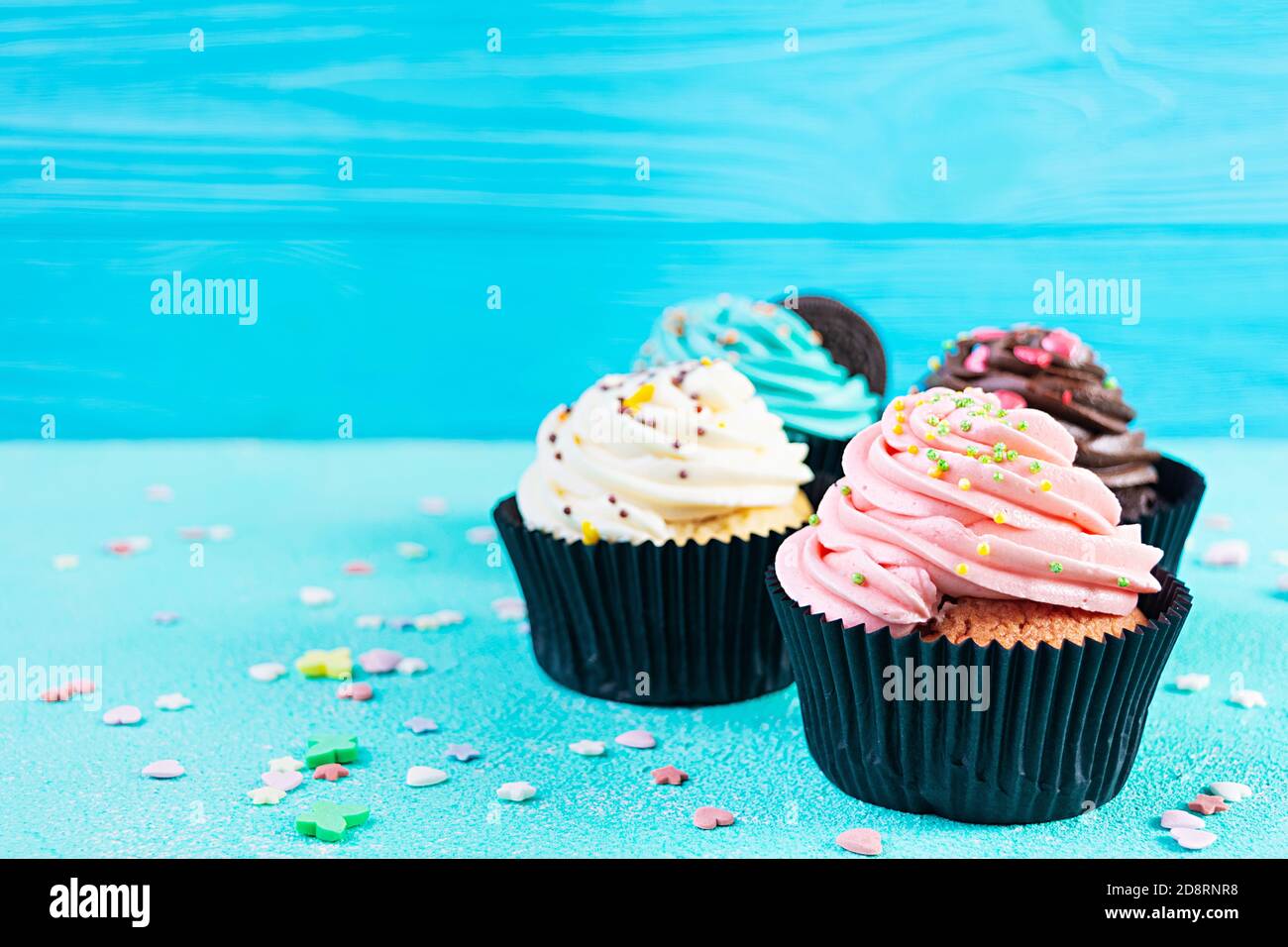 Tasty colorful cupcakes isolated on blue background. Delicious cupcake Stock Photo