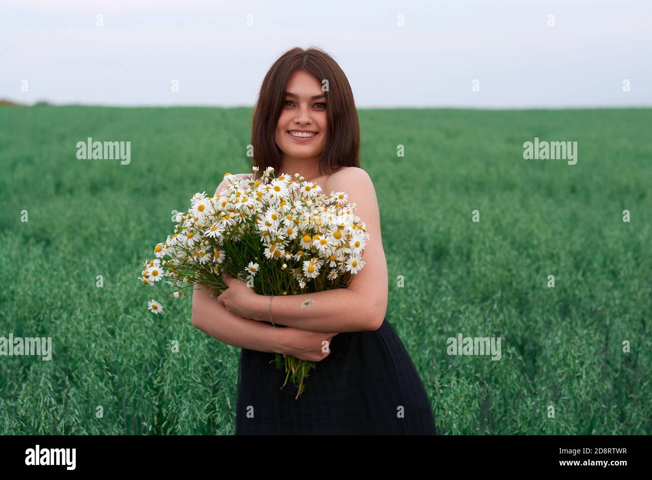 beautiful girl with a bouquet of daisies in a field of flowers Stock ...