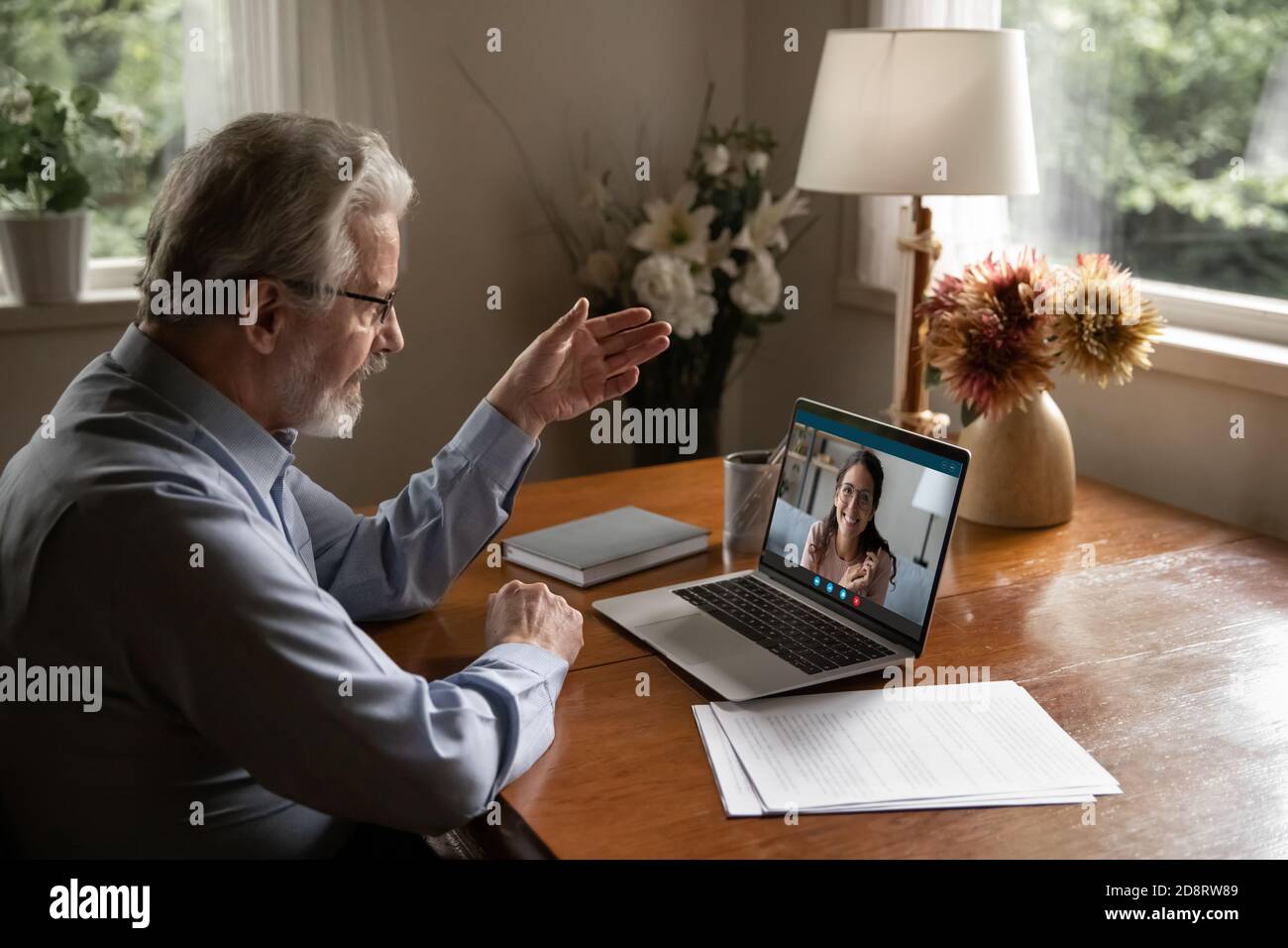 Mature man wearing glasses making video call to adult daughter Stock Photo