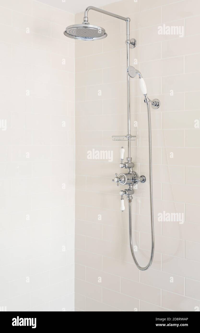 Shower with fixed rainfall shower head, slide rail and handset in a new, luxury bathroom, UK Stock Photo