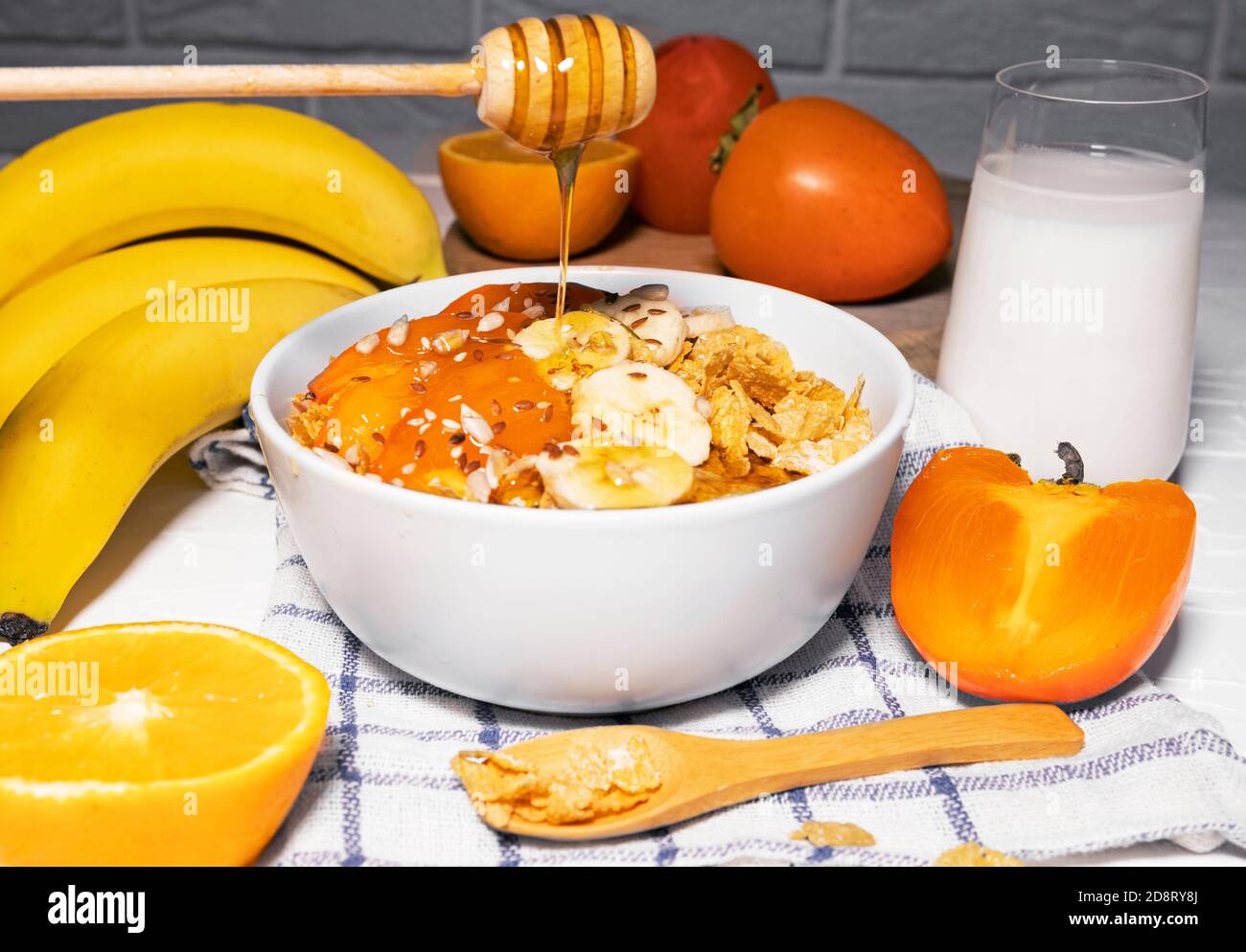 Corn Flakes Bowl with Banana, Milk, Persimmon, Orange and Honey on
