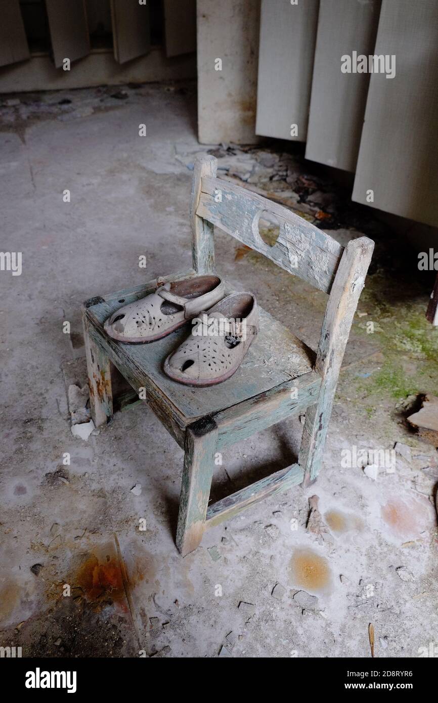 Small children's sandals in an abandoned kindergarten in Pripyat. Old children's shoes. Stock Photo