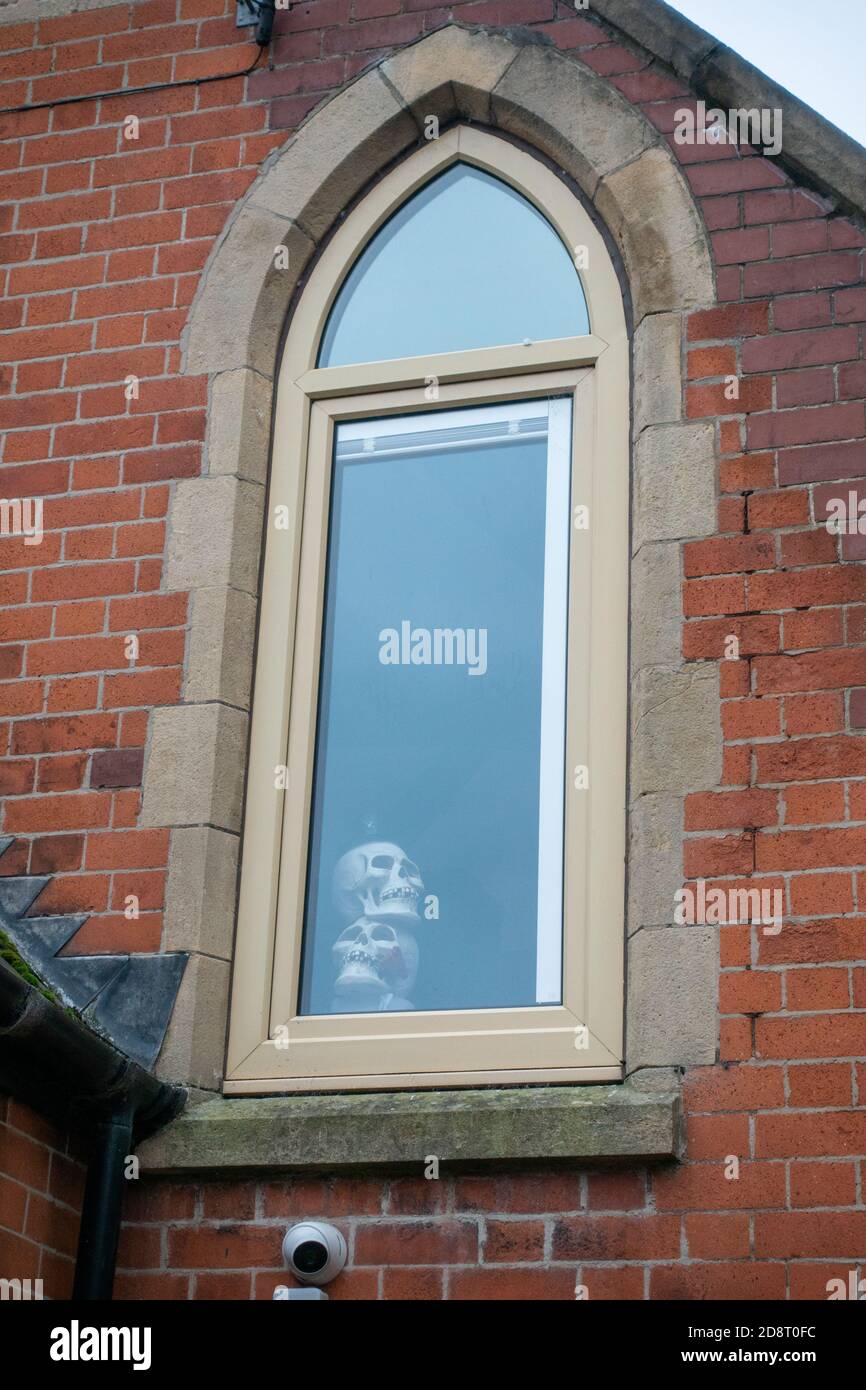 Halloween fake Skeleton hanging in old church window Stock Photo