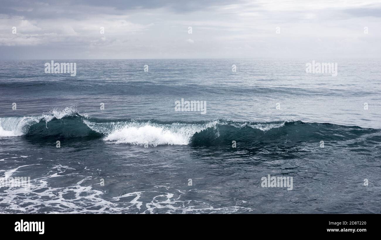 Small waves crashing on the sea, seascape horizon, peaceful and mighty nature, water element, freedom travel concept, sea before the storm Stock Photo