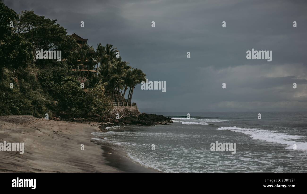 Dramatic beach with black sand before the storm, cloudy and dark weather, soft focus, film noise Stock Photo