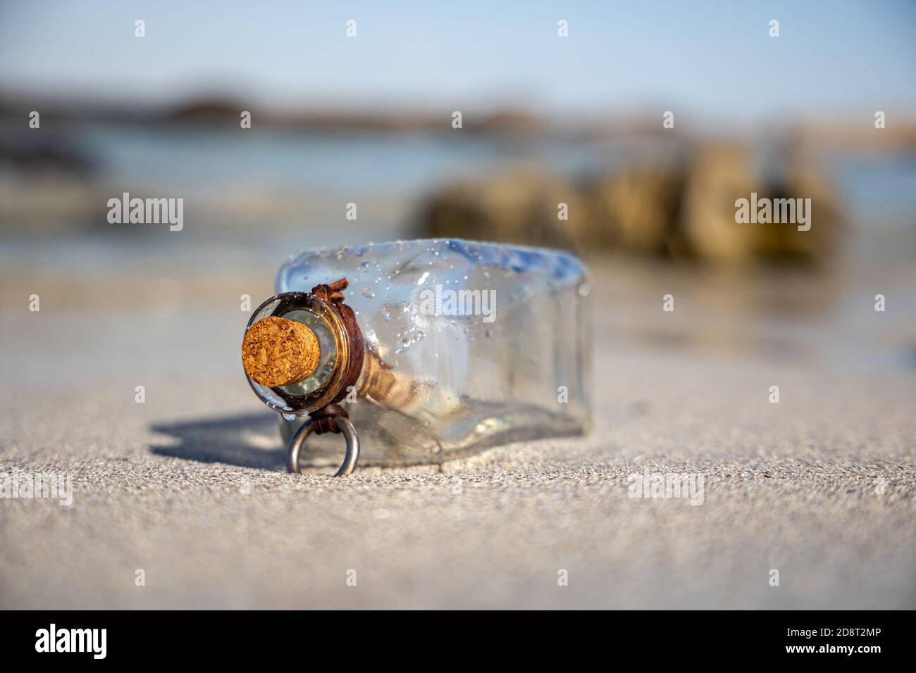 Message in the bottle against the Sun setting down Stock Photo
