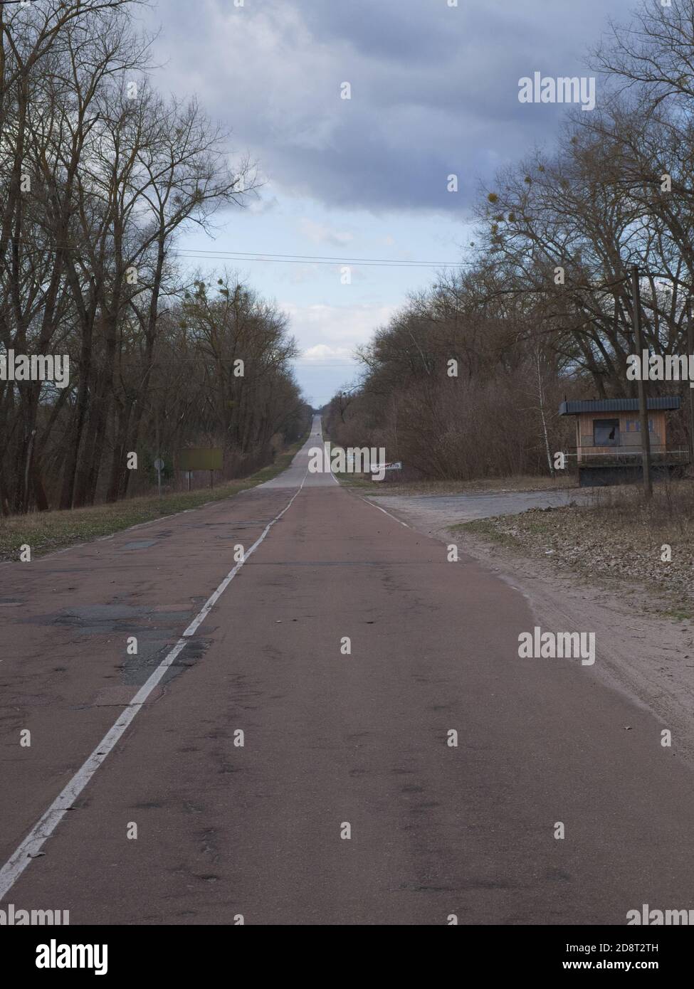 Long straight road to the Chernobyl radioactive exclusion zone. Stock Photo