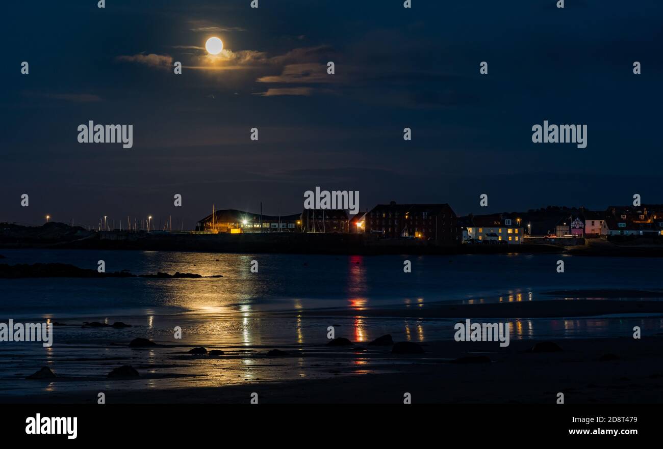 Hunter full moon rise over North Berwick skyline with water reflections, East Lothian, Scotland, UK Stock Photo