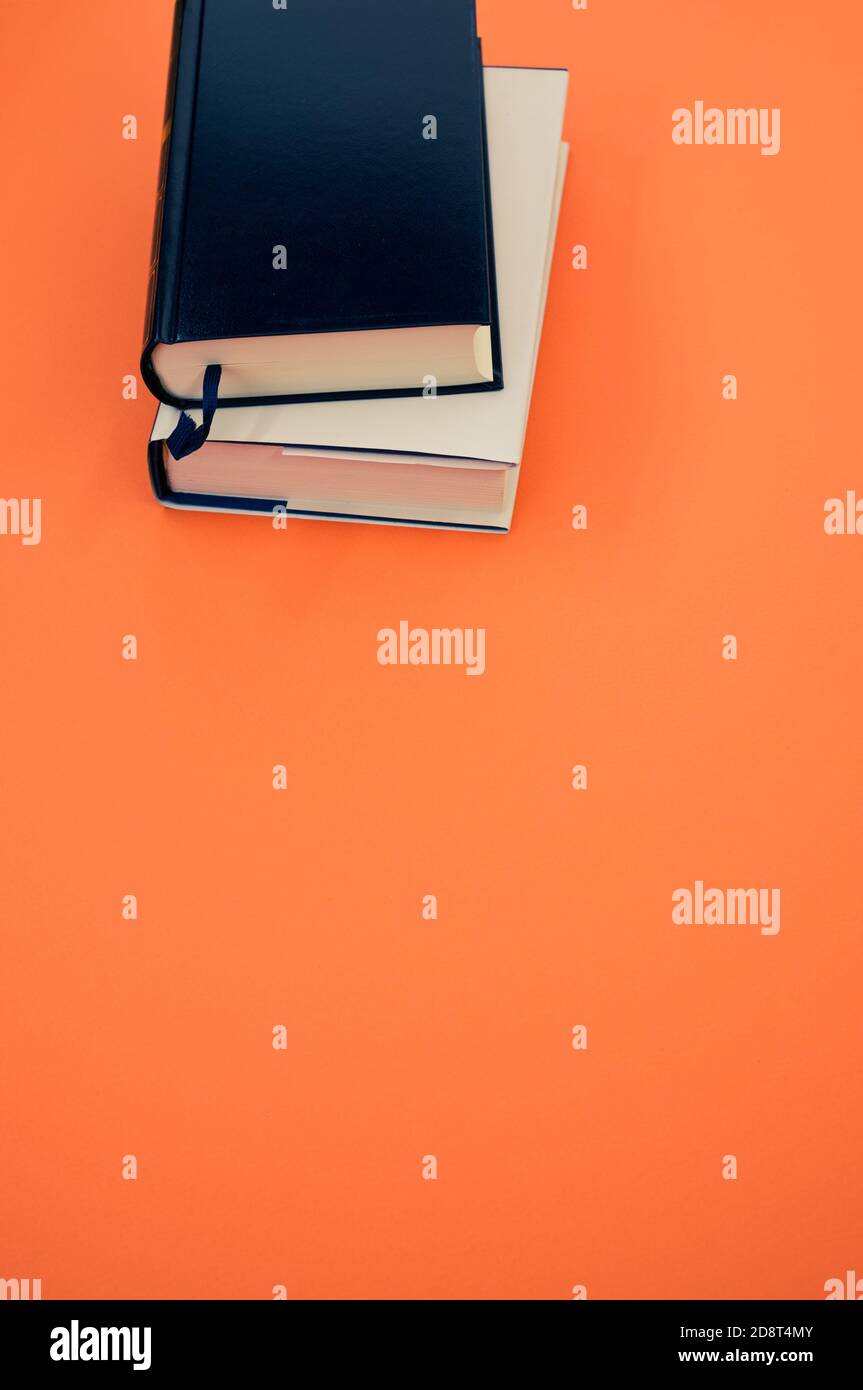 Vertical shot of books on an orange surface Stock Photo