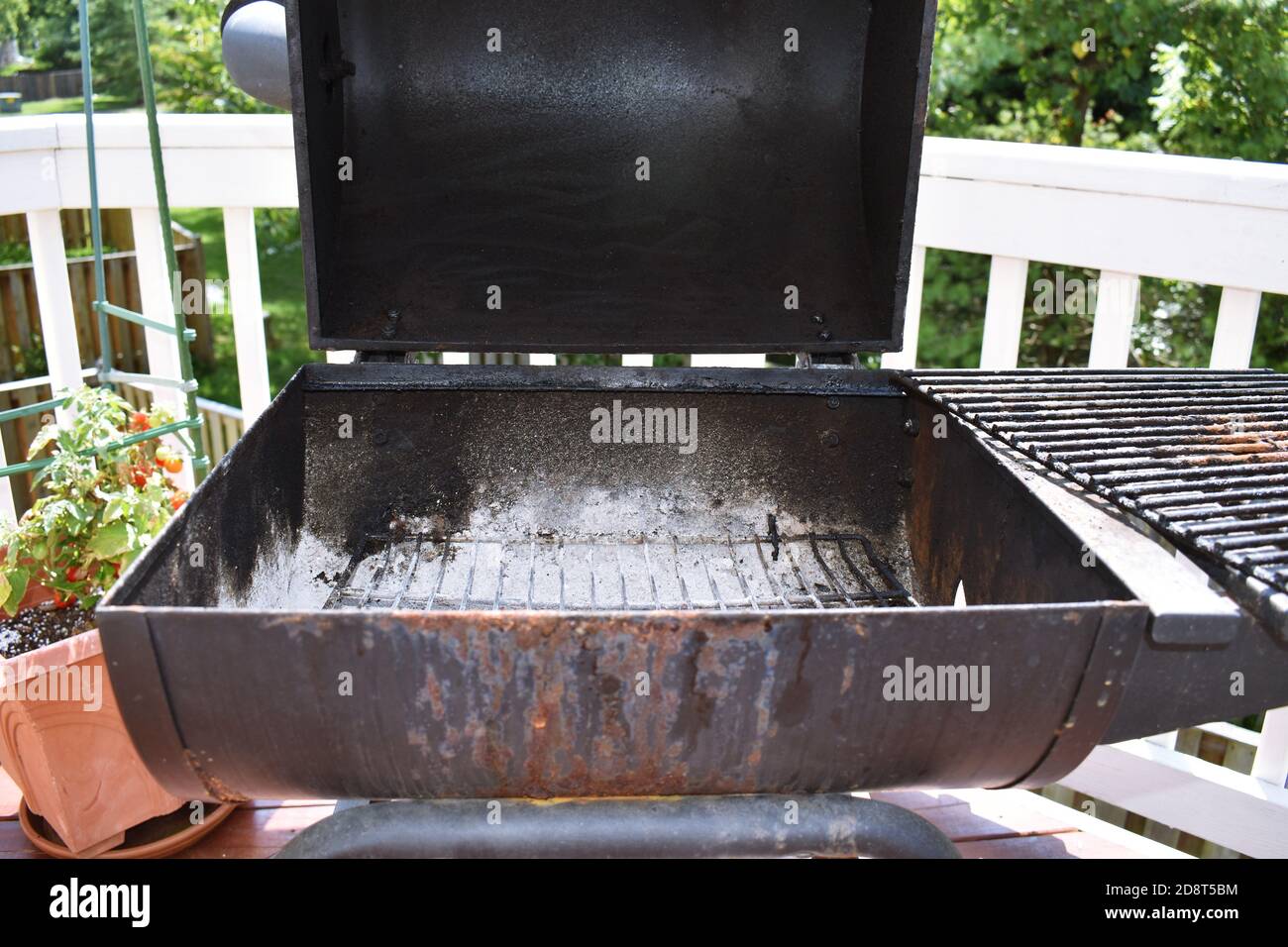 View of the open charcoal grill after use with ashes at the bottom of