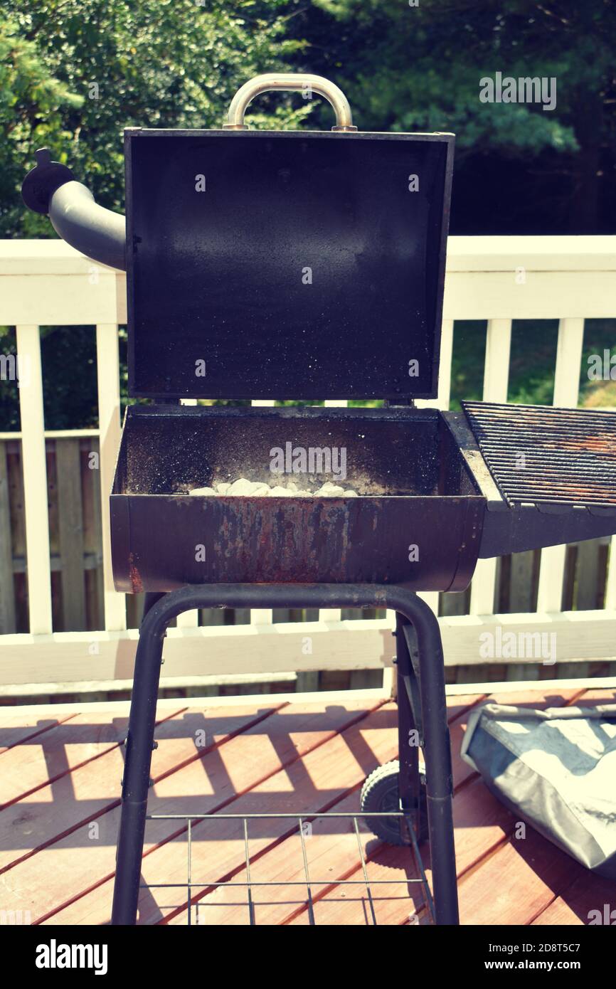 View of the open charcoal grill after use with ashes at the bottom of