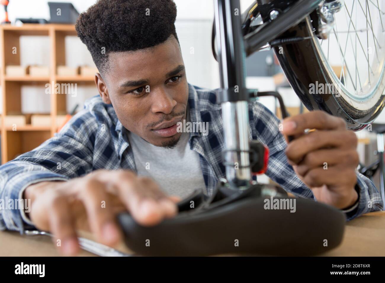 man securing bicycle seat with allen key Stock Photo Alamy
