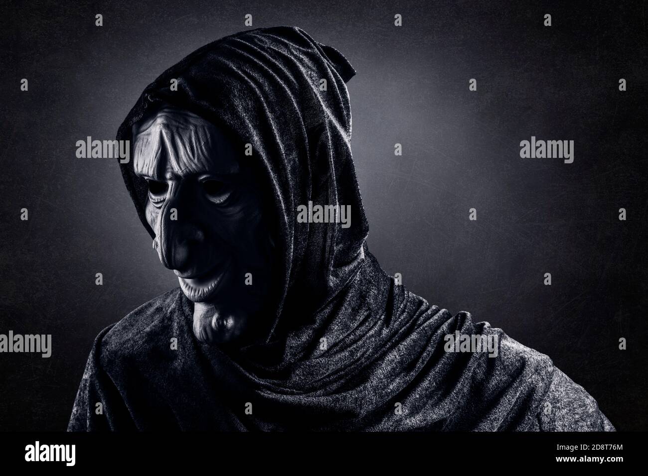 Portrait of a scary witch in hooded cloak Stock Photo - Alamy