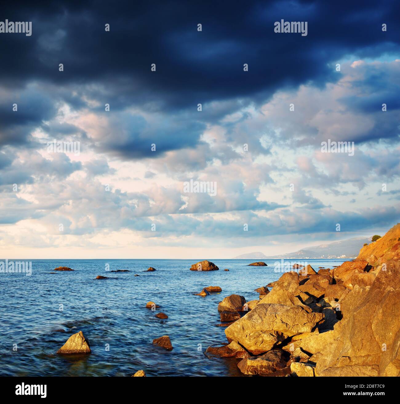 Summer landscape with the sea, stones and the cloudy sky. Crimea, Ukraine. Stock Photo