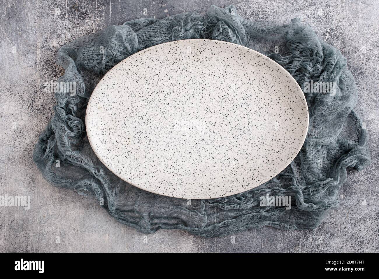 Empty oval plate with gauze on concrete Stock Photo