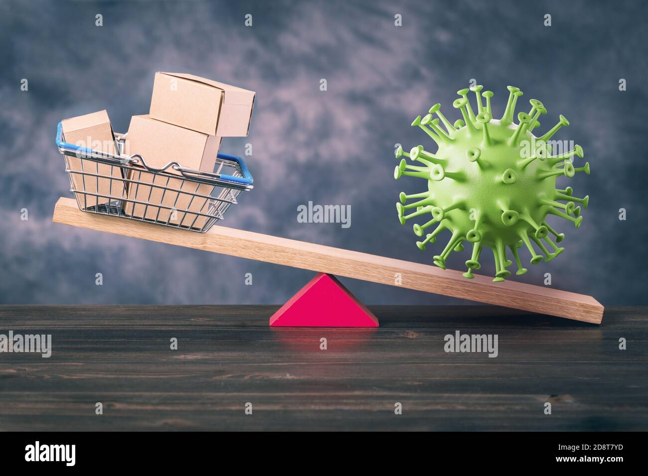 Shopping basket and coronavirus on seesaw Stock Photo
