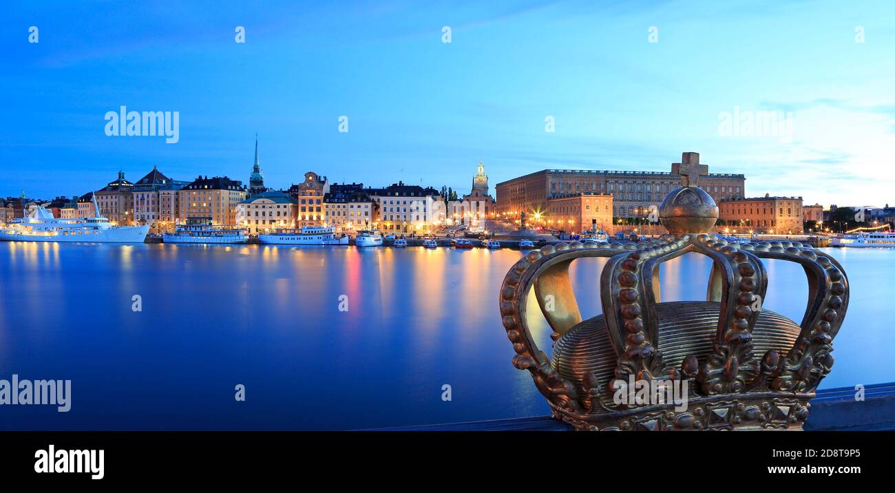 Stockholm's Old Town (Gamla Stan) reflected into the lake at dusk with the royal crown on the foreground, Sweden Stock Photo