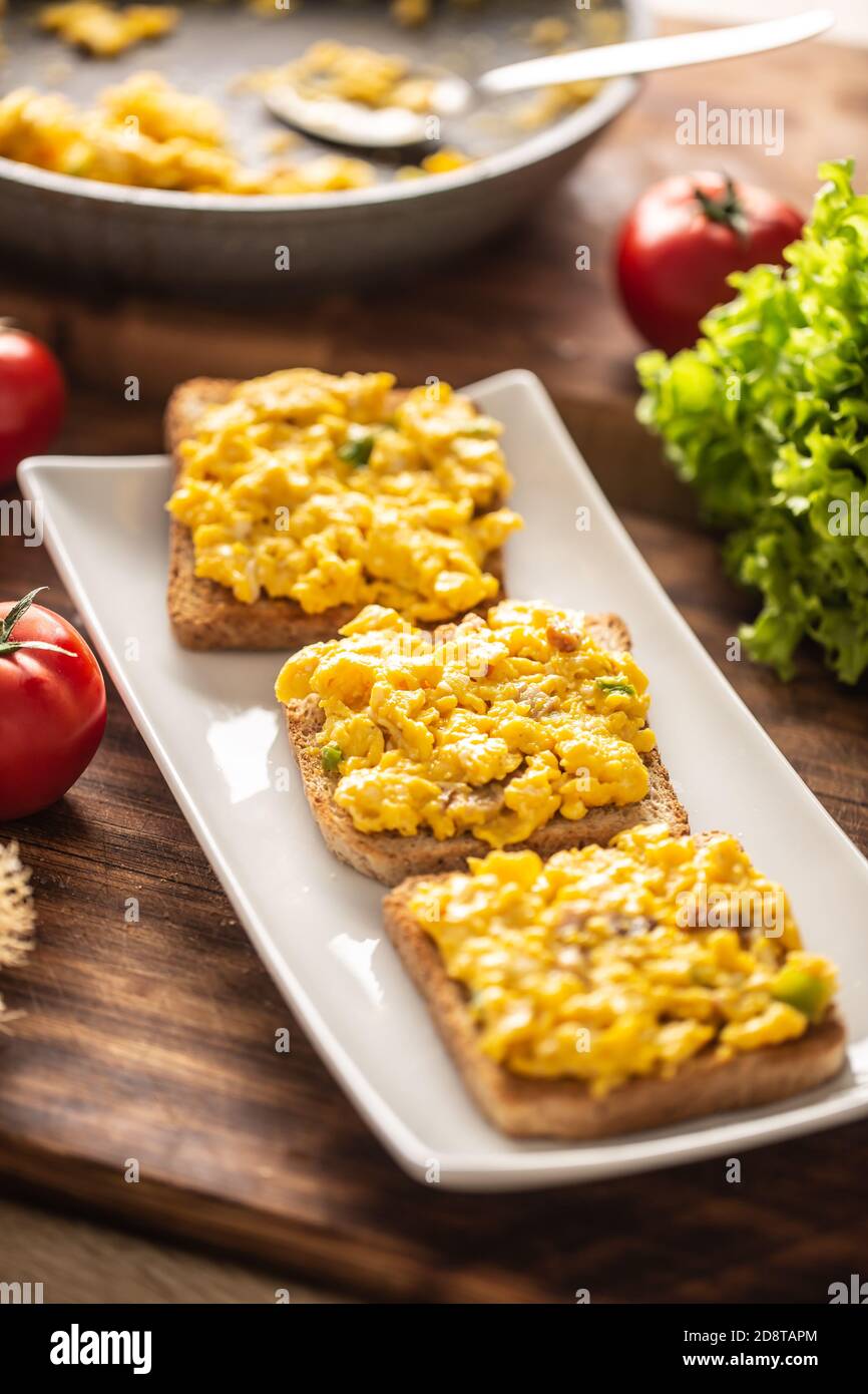 Scrambled eggs on toasts served on a plate Stock Photo