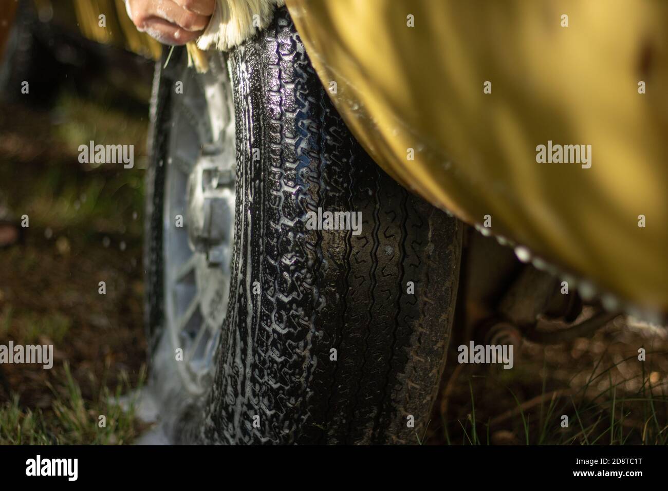 A young men washing an old vintage car Stock Photo