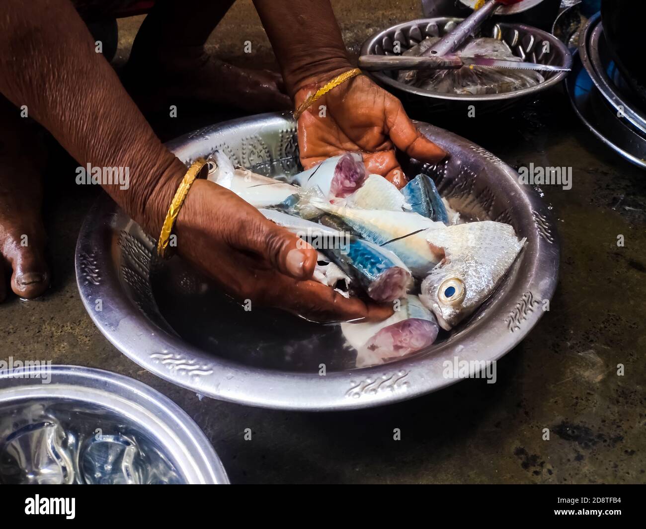 Fresh Raw Fish cutting on closeup . Woman cutting raw fish in home for