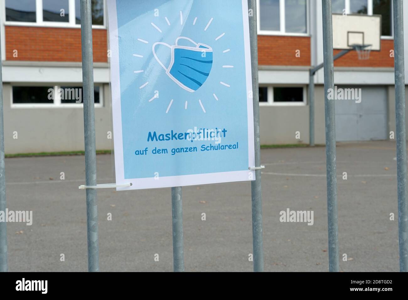 A sign poster on school yard in German language saying: a face mask is obligatory on the whole school ground. A new normal in Switzerland. Stock Photo