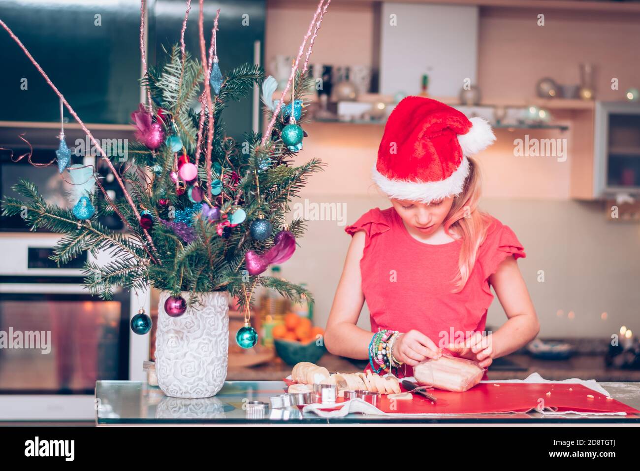 lovely blond girl preparing sweets in christmas atmosphere in the home kitchen Stock Photo