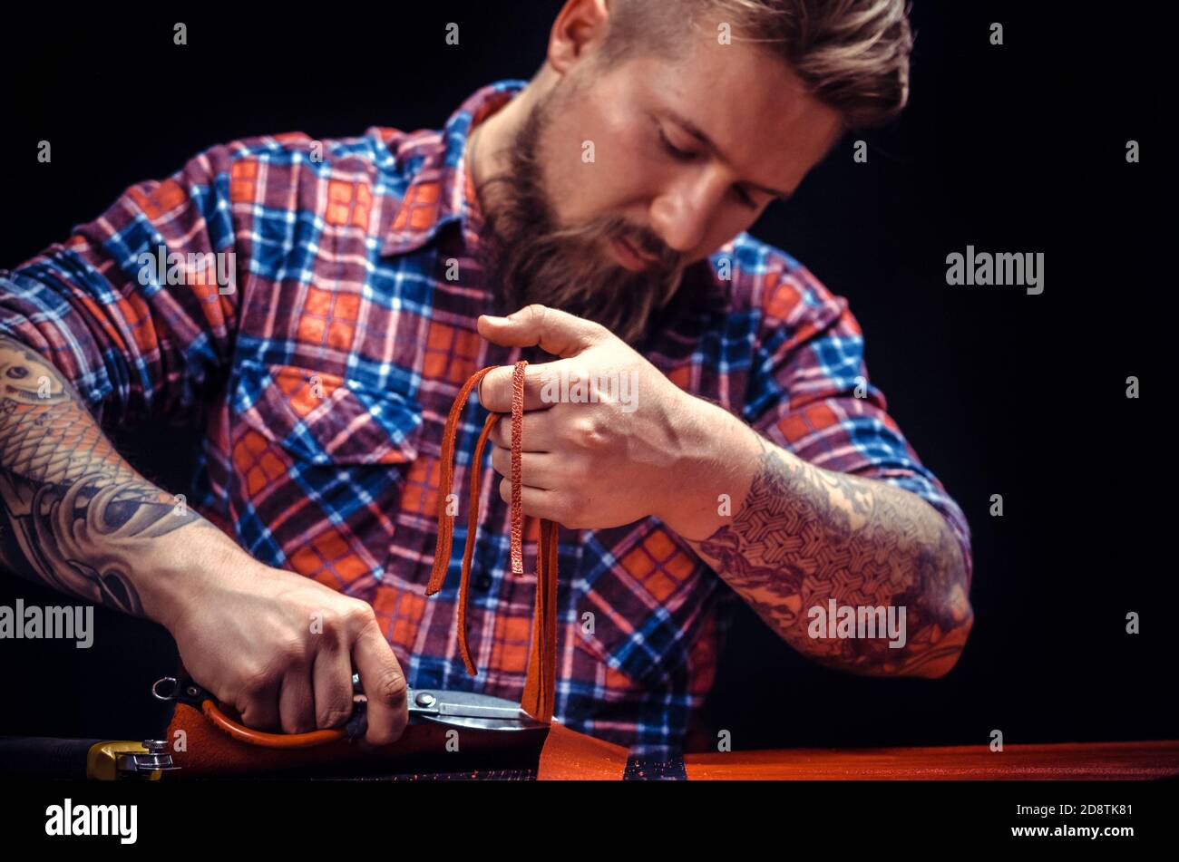 Professional Leather Worker makes quality products at the workshop Stock Photo