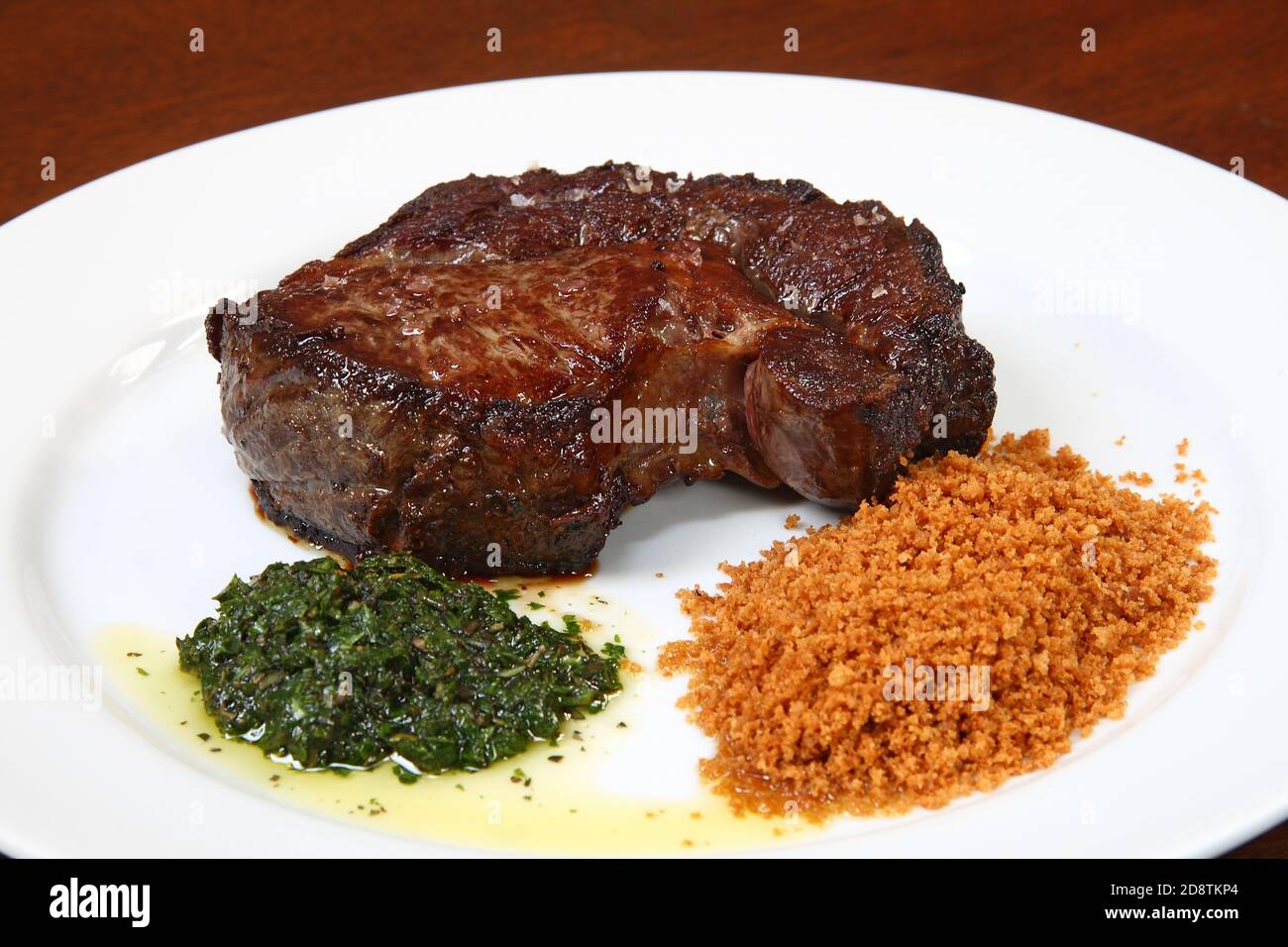 Steak with fried garlic and chimichurri sauce Stock Photo
