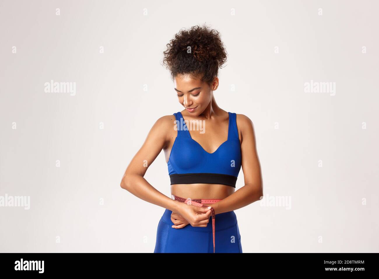 Muscular female measuring her waist hires stock photography and images