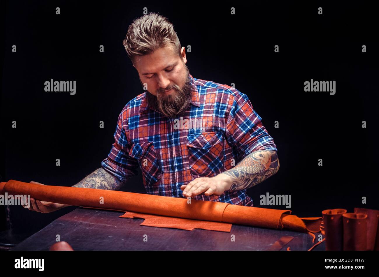 Artist working with leather processing a leather workpiece Stock Photo