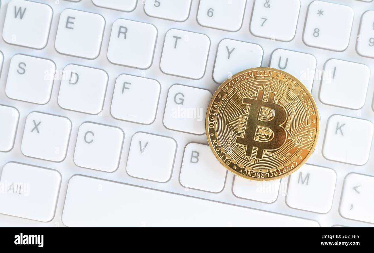 Crypto currency gold bitcoin on white computer keyboard, virtual cryptocurrency concept Stock Photo