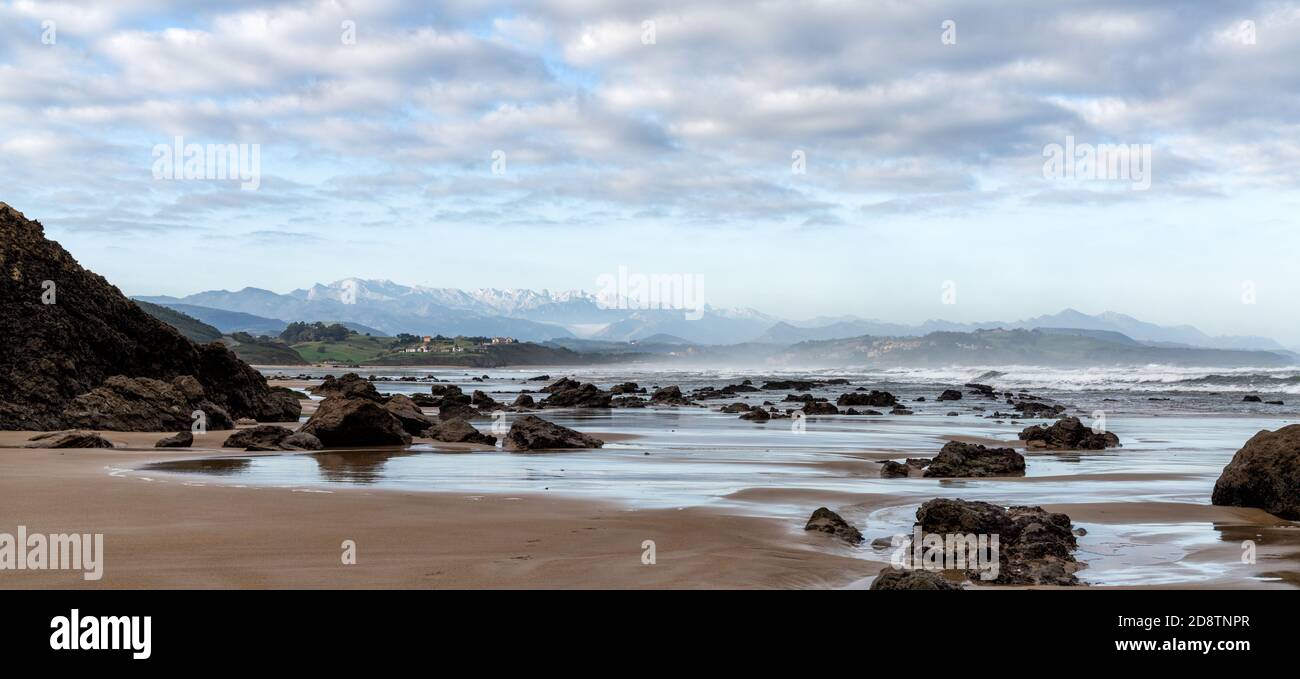 A view of wild and rocky and sandy beach at low tide Stock Photo