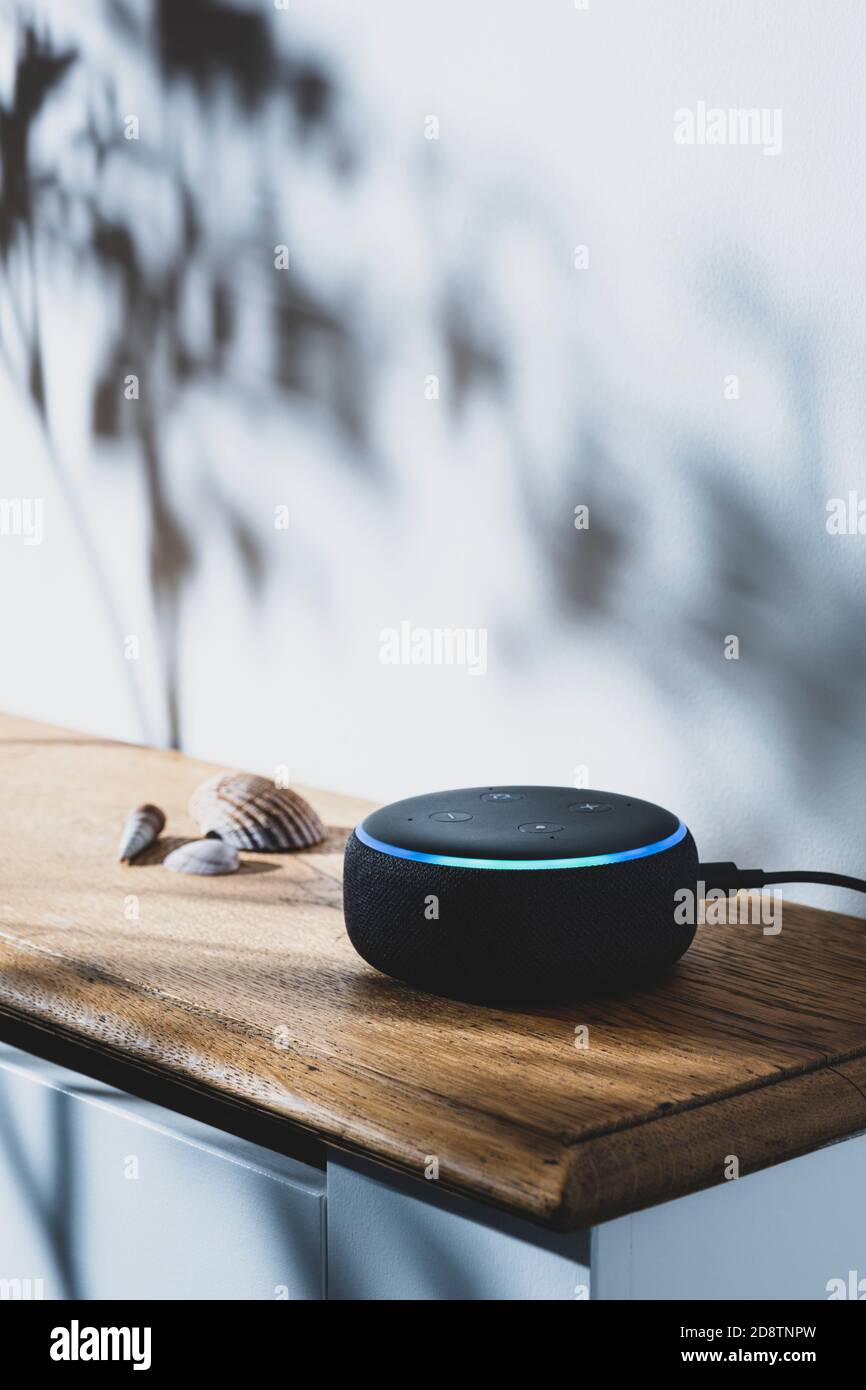 Amazon Echo Dot smart speaker with blue light showing. Stock Photo