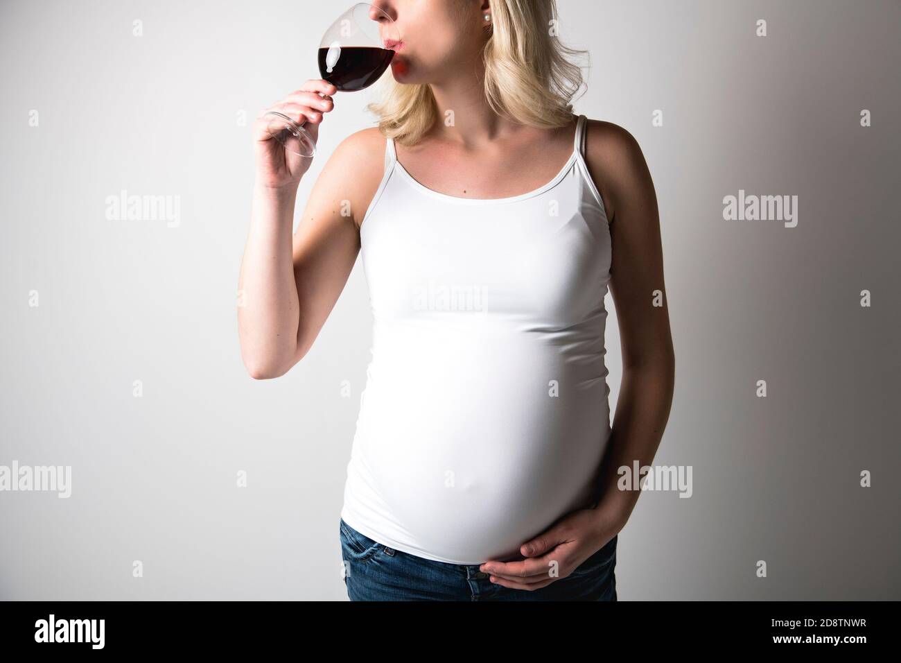 Pregnant women with wine glass on studio white Stock Photo Alamy
