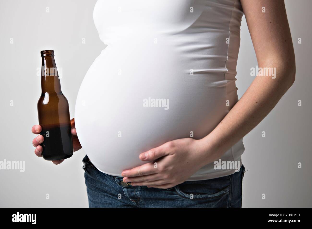 Pregnant women drinking beer on studio white Stock Photo