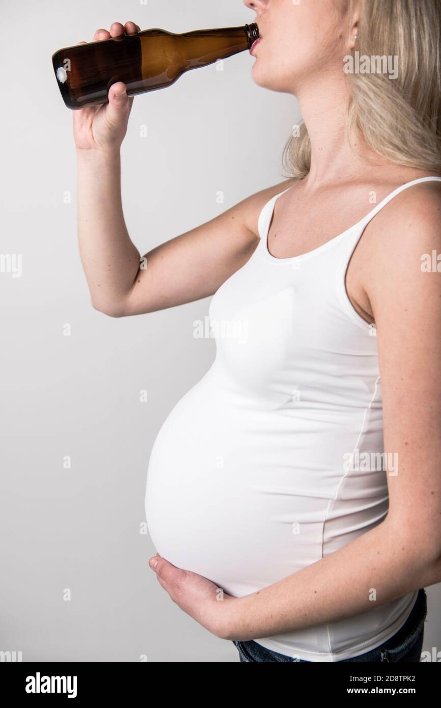 Pregnant women drinking beer on studio white Stock Photo Alamy