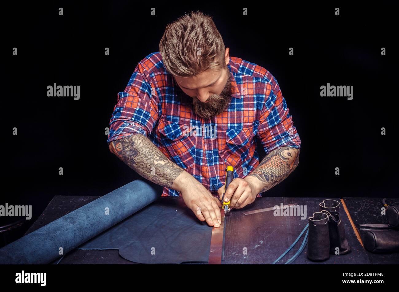 Handicraftsman processing a leather workpiece Stock Photo