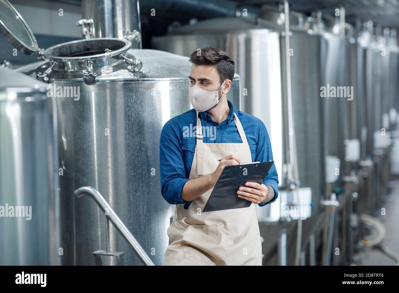 Worker controls data on production line in factory Stock Photo