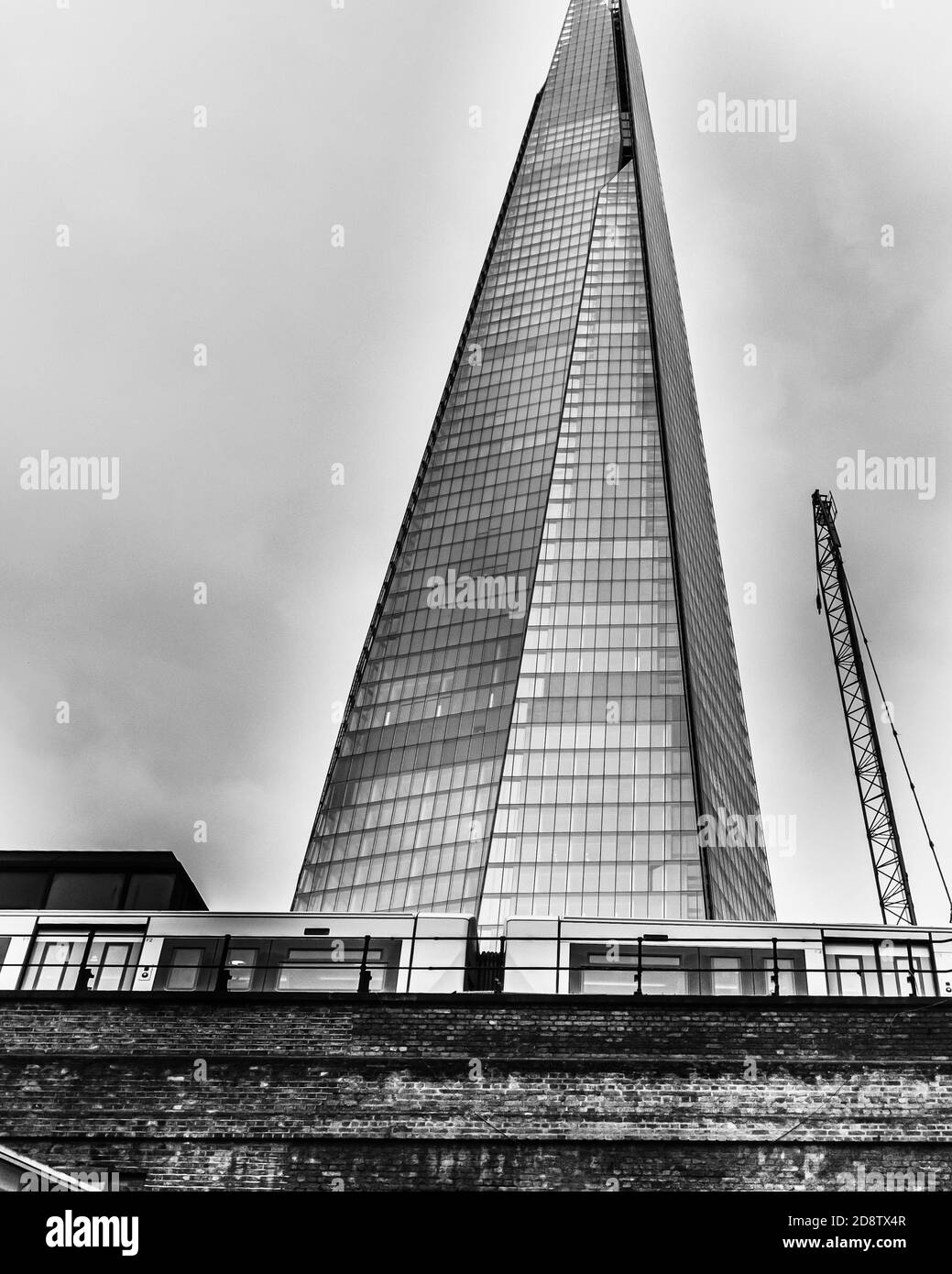 London, UK, December 7, 2013: The Shard behind London Bridge Station against sky, converted in black-and-white Stock Photo