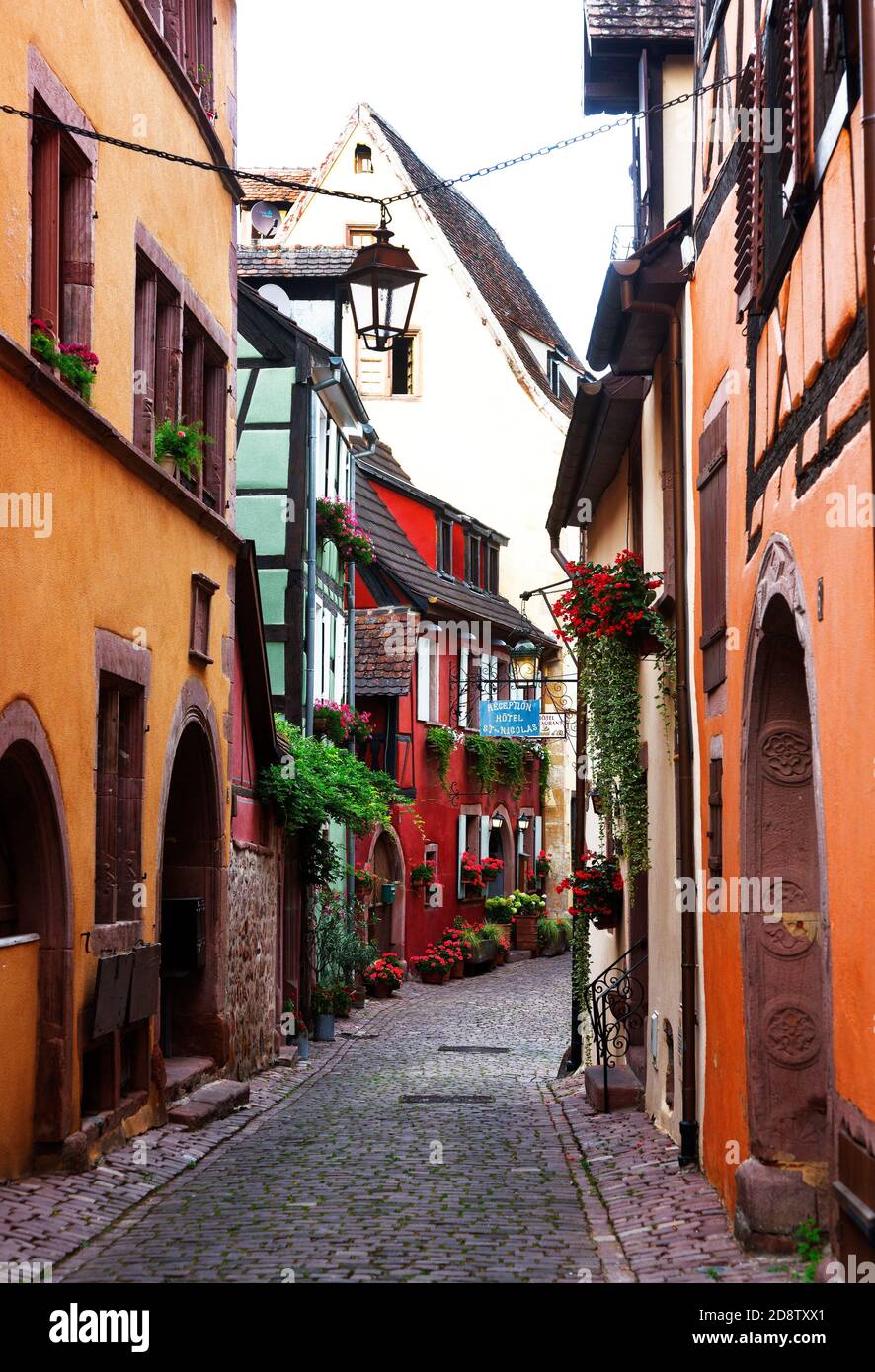 Cobblestone street and colorful medieval village in Alsace region, Riquewihr, France Stock Photo