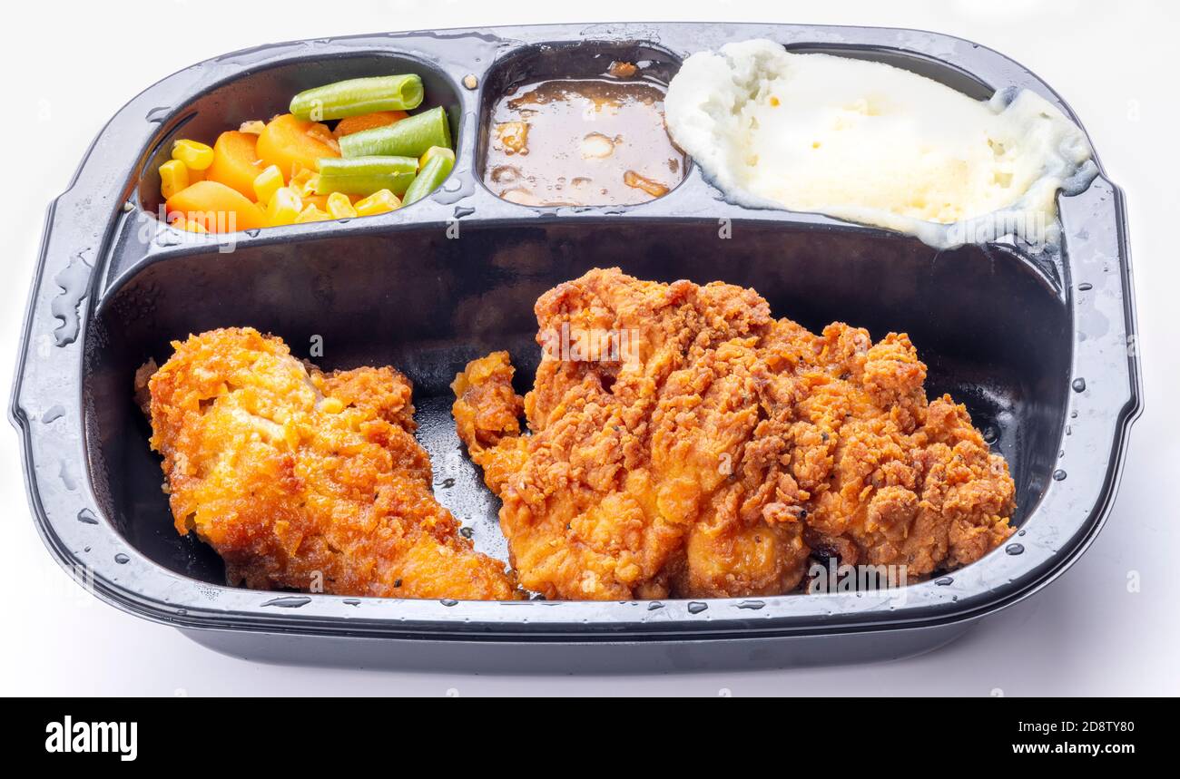 Chicken TV dinner with potatoes spilling over Stock Photo - Alamy