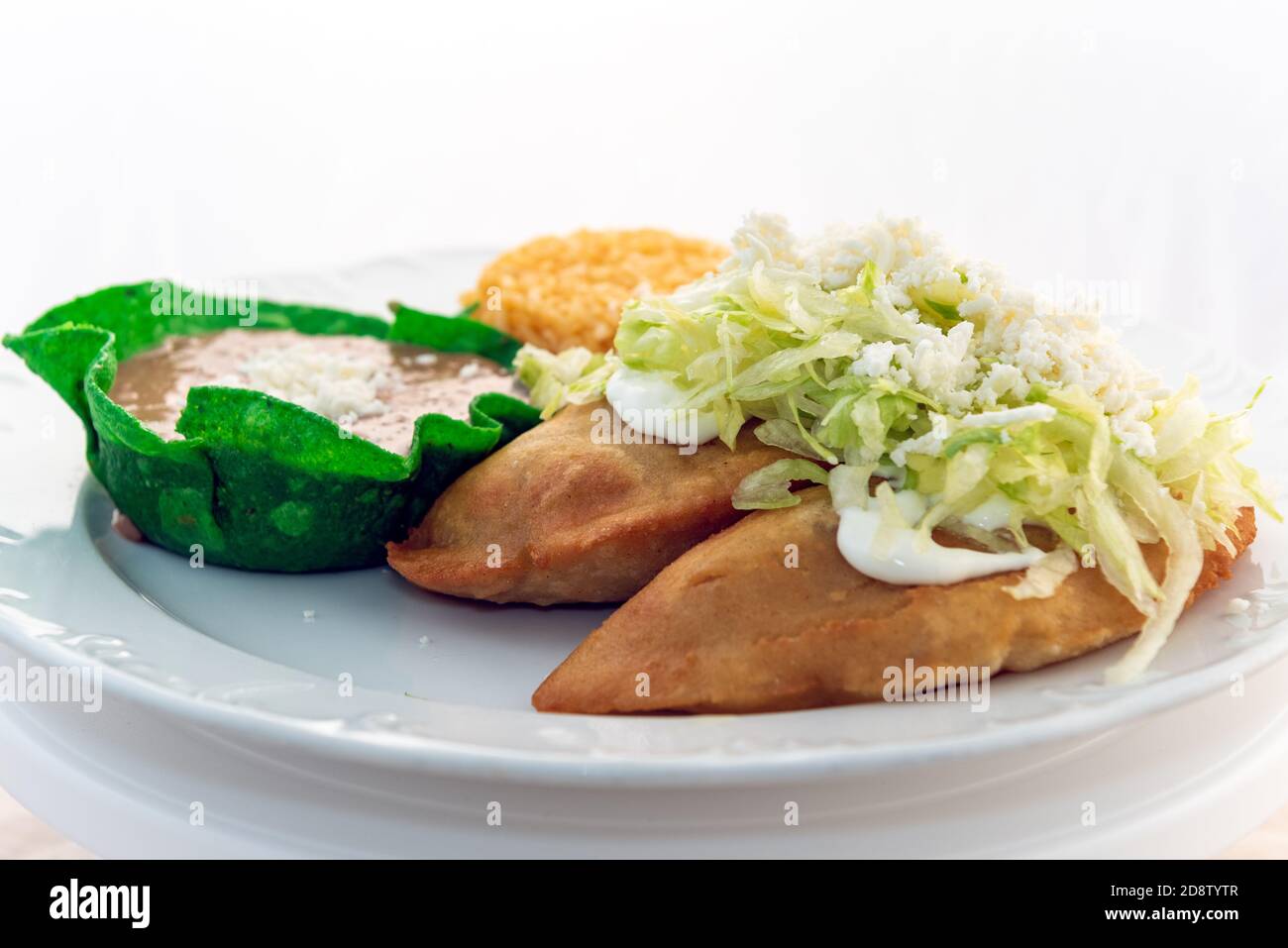 Fried Quesadillas served with rice and tortilla chip bowl refried beans looks and tastes appealing. Stock Photo